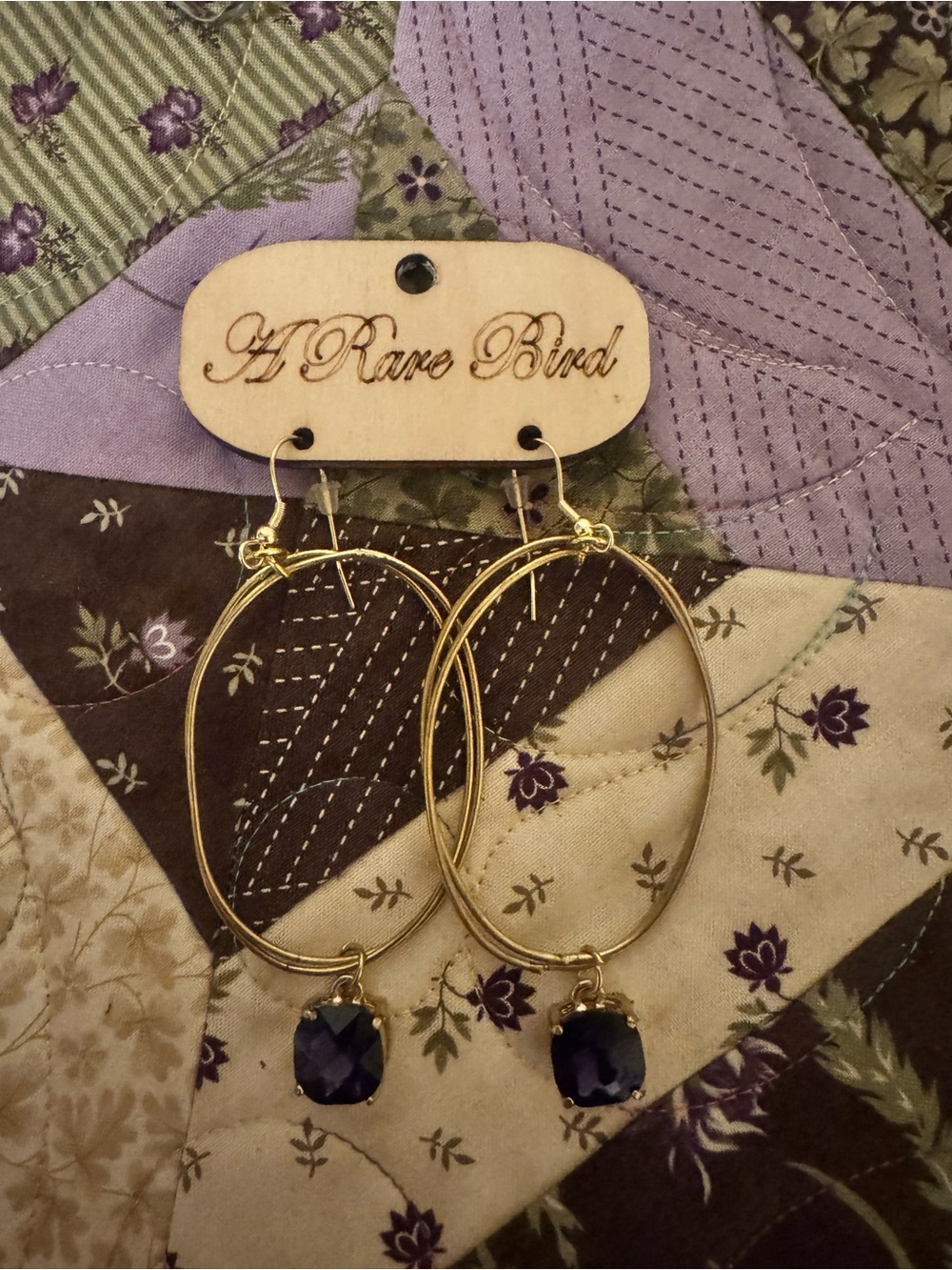 A Rare Bird Gold Hoop Earrings with Purple Gem Drops